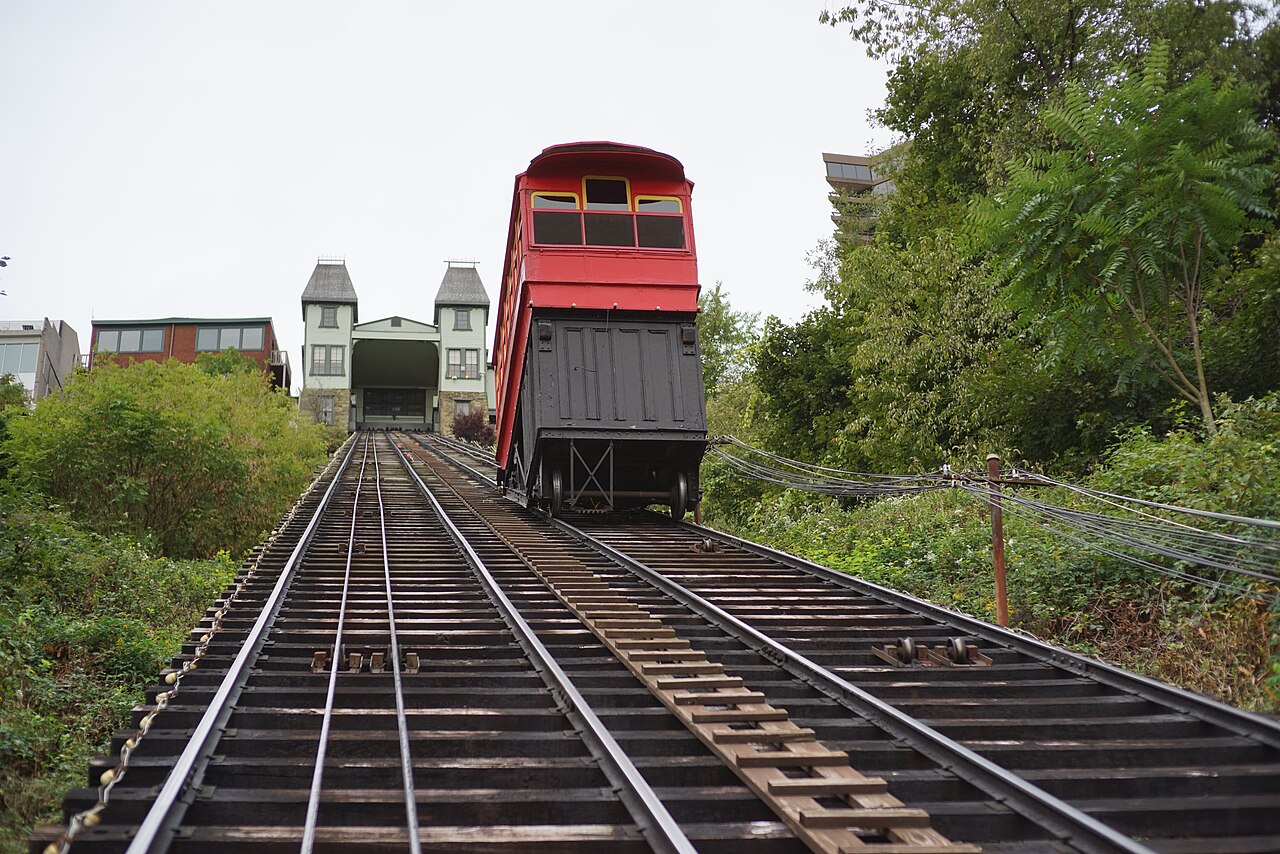 A red Duquesne Incline car overlooking downtown Pittsburgh
